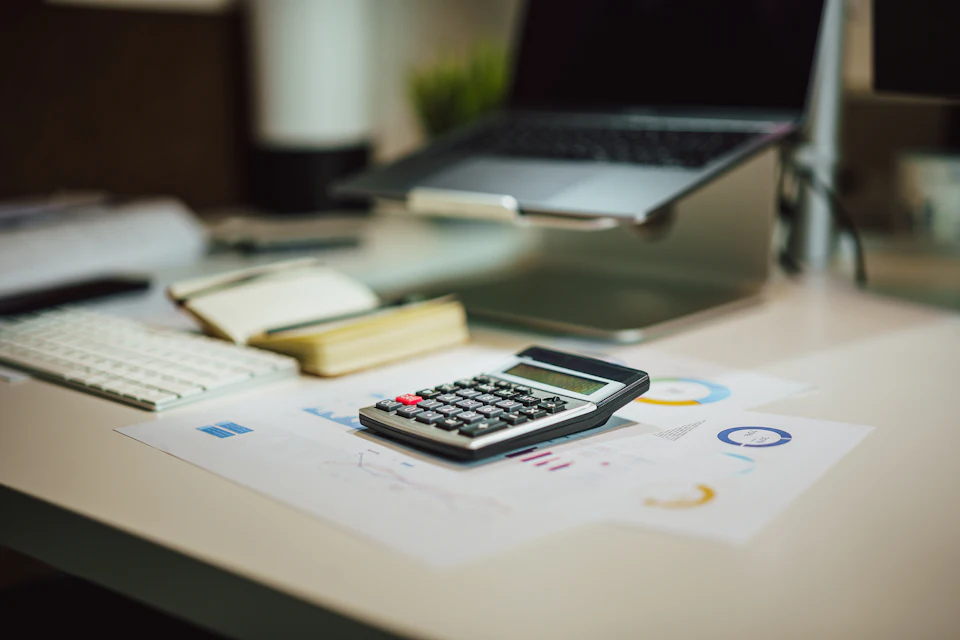 Calculadora y documentos sobre una mesa